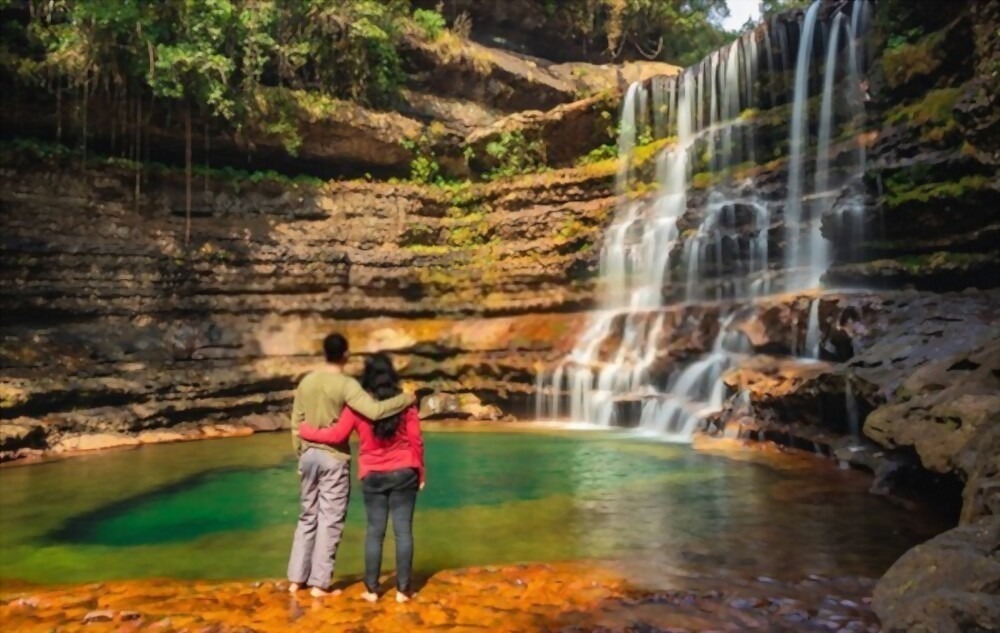 couple standing near waterfall flowing streams.