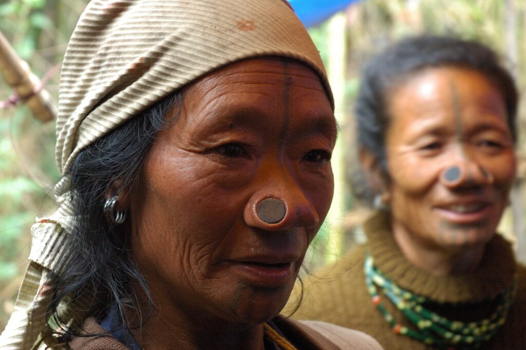 Two Apatani tribal women, the indigenous tribe of Ziro, Arunachal Pradesh, dressed in traditional clothing.