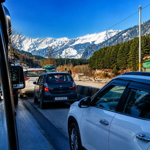 Manali road traffic with snow covered mountains Himachal Pradesh tour package journey